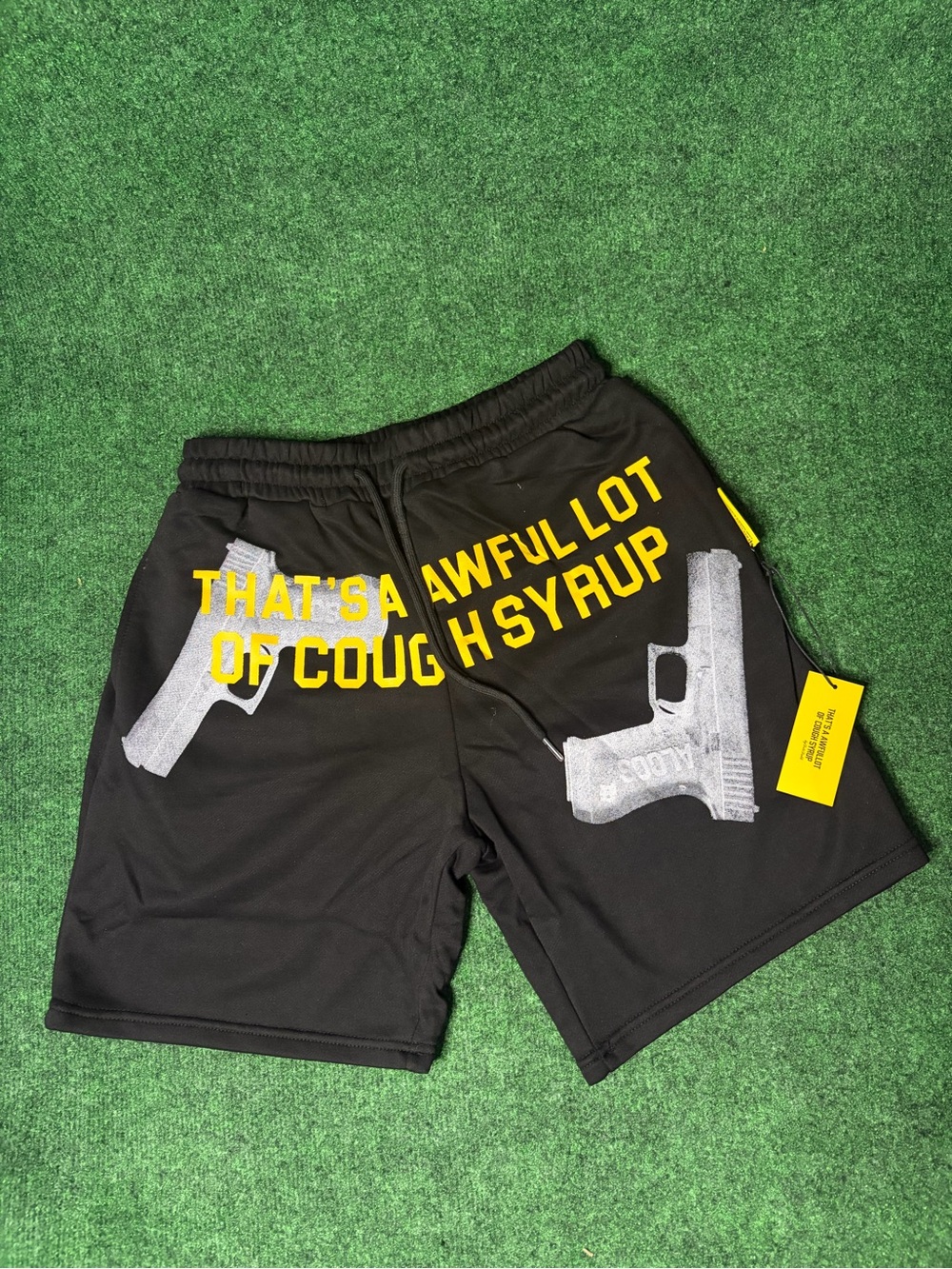 Black Graphic Athletic Shorts with Yellow Text and Gun Motif